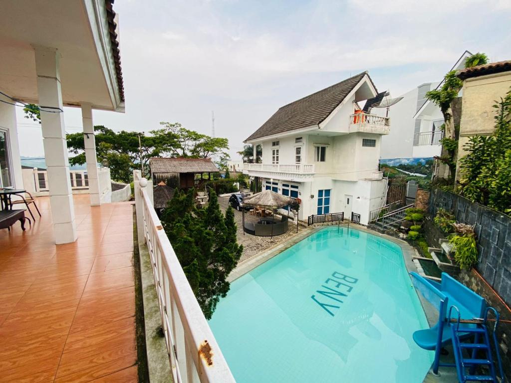 a house with a swimming pool on a balcony at Villa Benny Gsp Cipanas in Cibadak