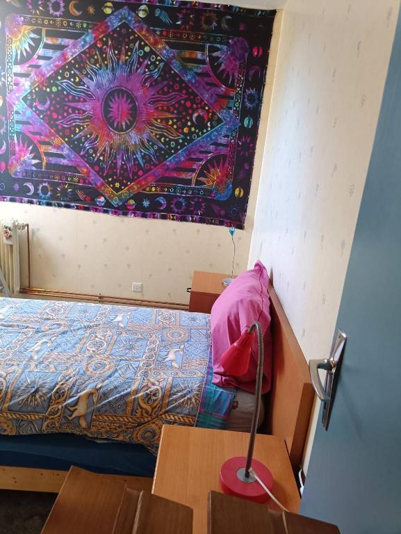 Cette chambre dispose d'un lit et d'une peinture murale. dans l'établissement Lit double & lit simple Tv Netflix & Amazon Vidéo, à Fruges