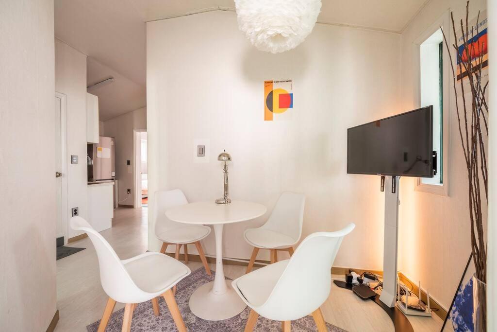 首尔Hongdae Modern House的白色的用餐室配有桌子和白色的椅子