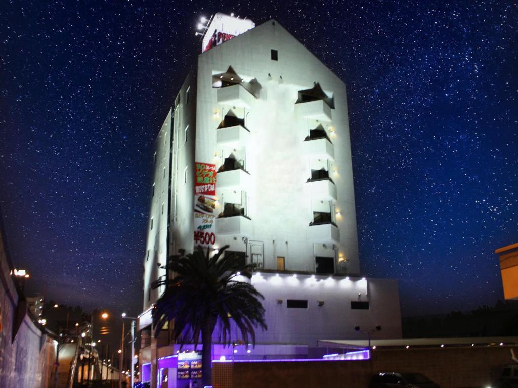北九州市にあるレステイ ペントハウス（大人専用）の夜間の窓のある白い大きな建物