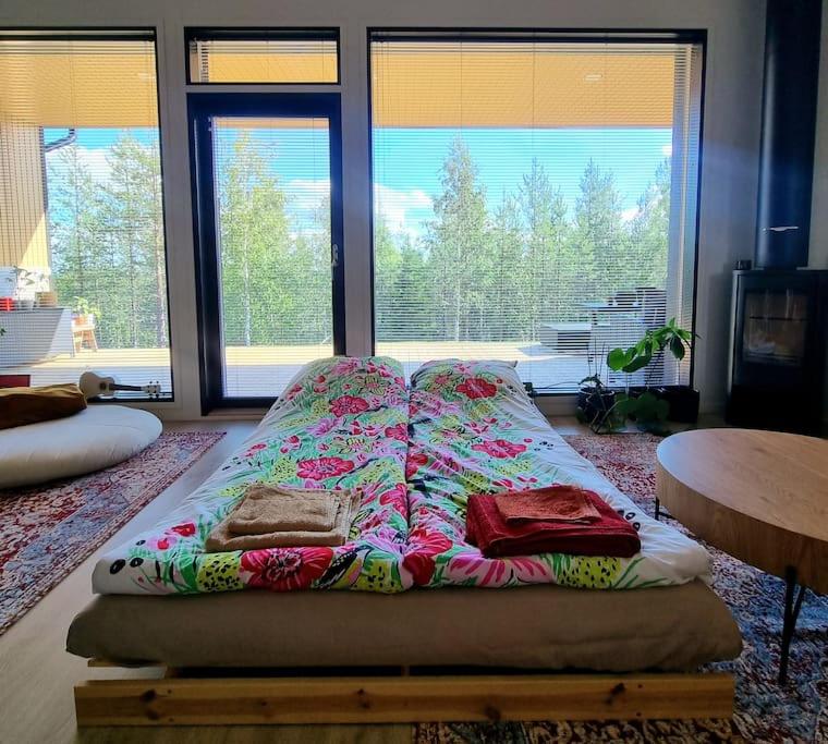 een bed met kussens in een kamer met ramen bij Holiday Black Pearl in Rovaniemi