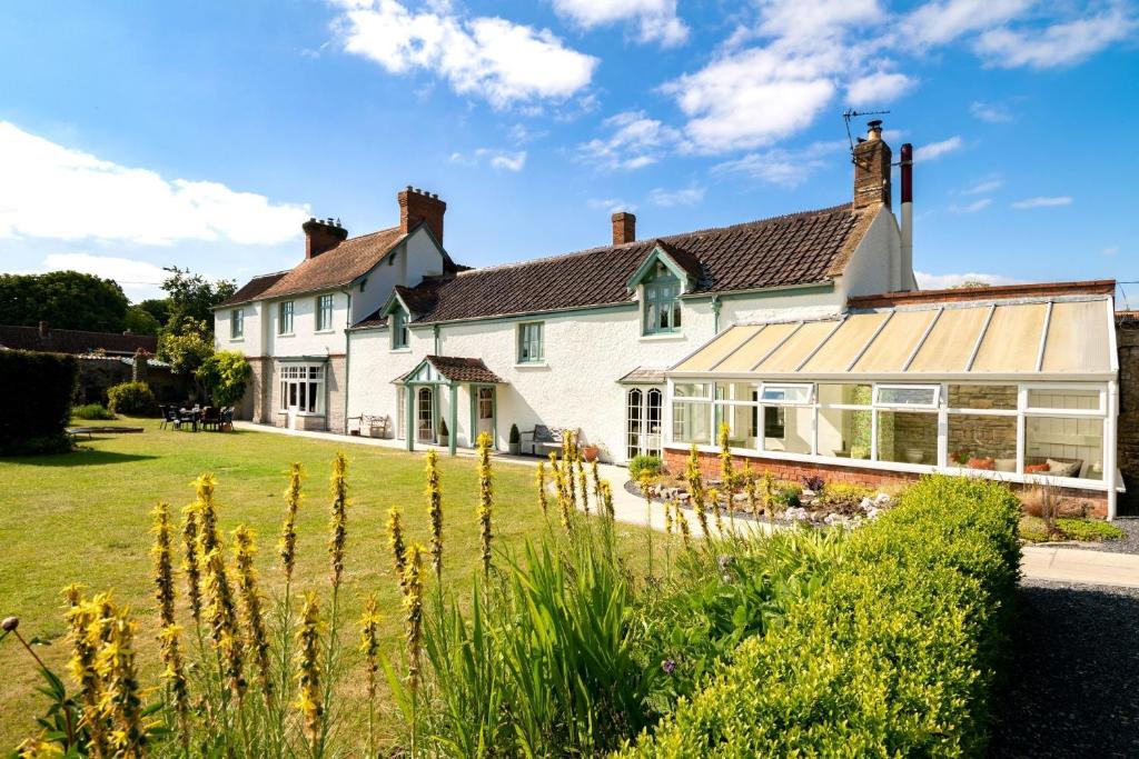 an exterior view of a house with a garden at Cossington Park House in Cossington