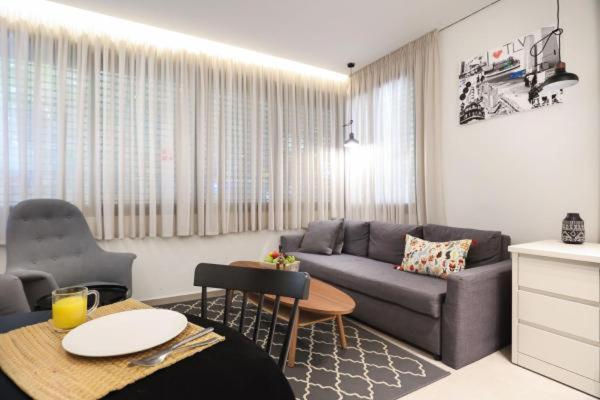 a living room with a couch and a table at Cozy Apartment in the Heart of Tel Aviv Sea N' Rent in Tel Aviv