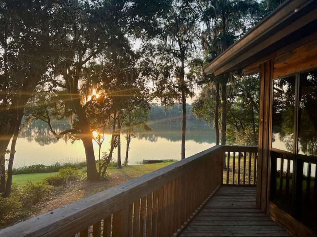 a porch of a house with a view of a lake at Hammock Trail Lake - Lake Park - Valdosta Area in Lake Park