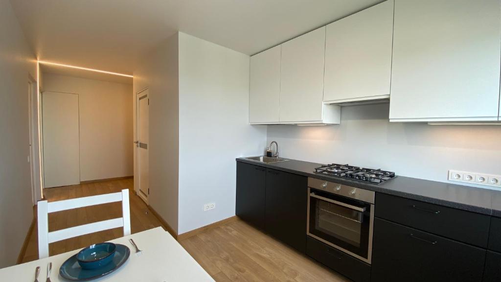 a kitchen with white cabinets and a stove top oven at C3 apartment in Kėdainiai in Kėdainiai