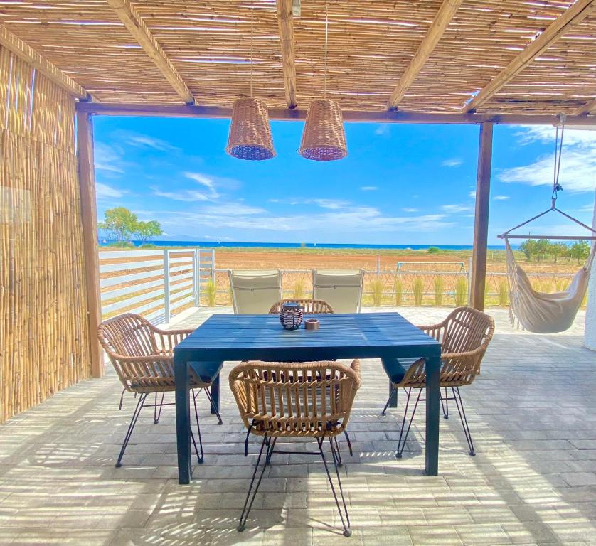 einen blauen Tisch und Stühle auf einer Terrasse in der Unterkunft Boho Vibes Beachfront Detached House in Análipsis