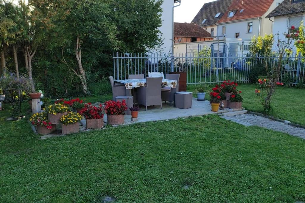 a garden with a table and chairs and flowers at Gemütliches und Zentral in Bruchköbel