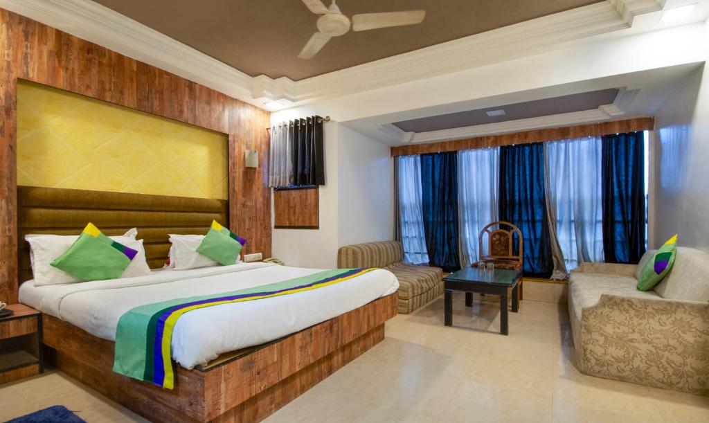 une chambre d'hôtel avec un lit et un canapé dans l'établissement Treebo Trend Shree Krishna Palace, à Ahmedabad