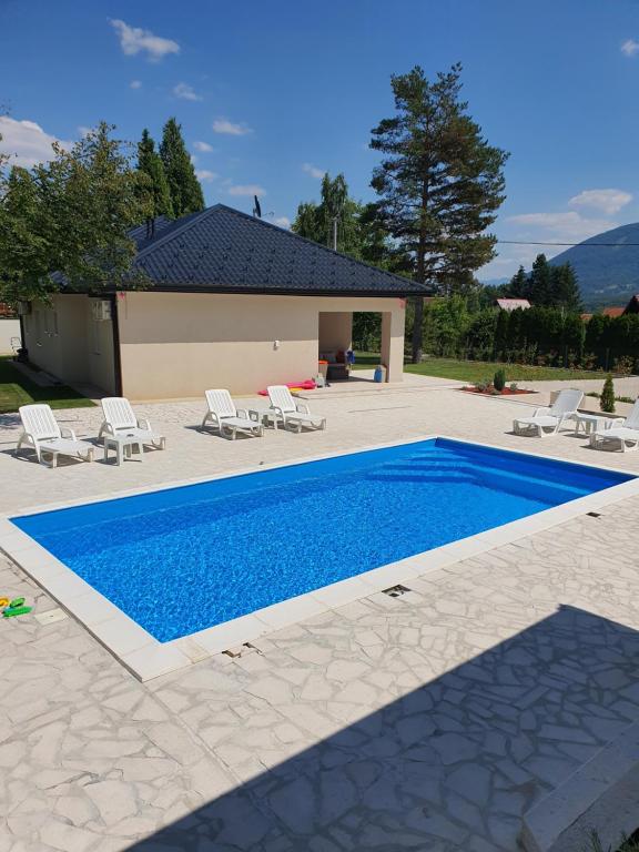 a swimming pool with chairs and a house at Villa Aida in Sarajevo
