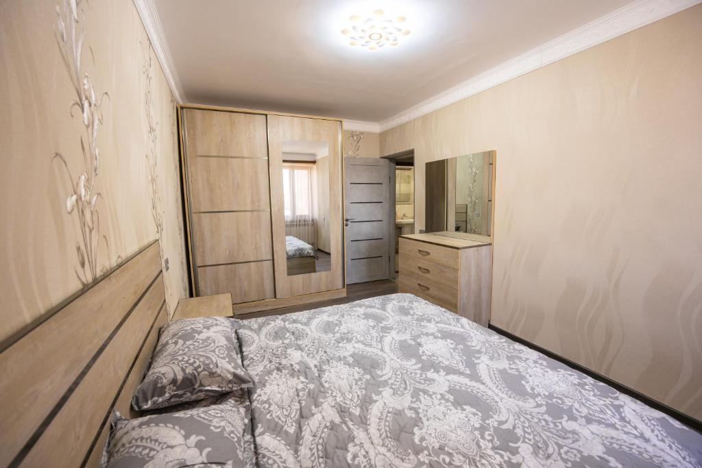 Apartment in Ejmiactin في Vagharshapat: غرفة نوم بسرير وخزانة ومرآة