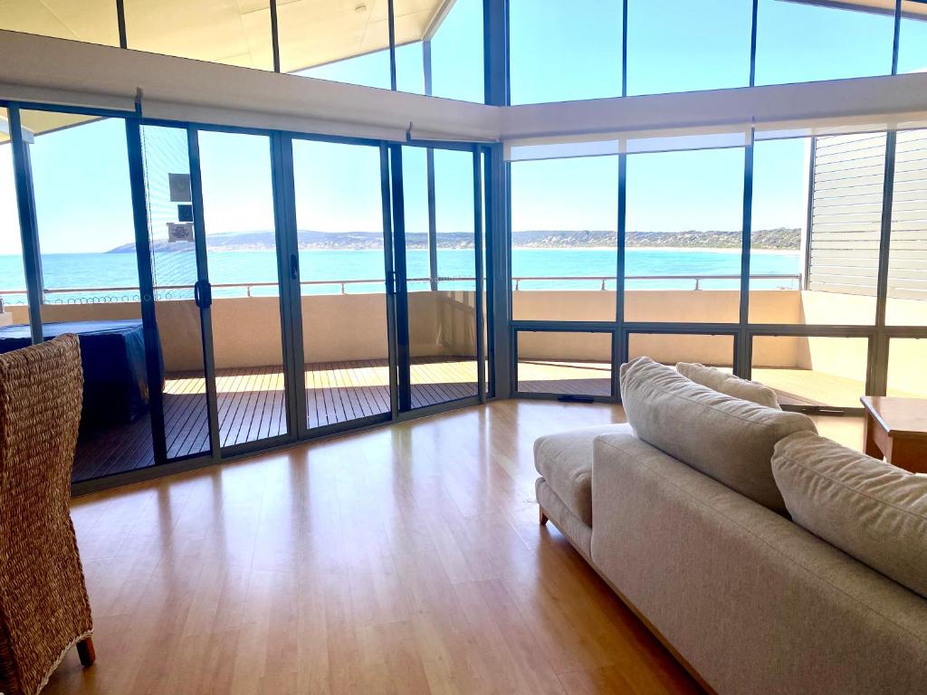 a living room with a couch and large windows at Birubi Holiday Homes Kangaroo Island in Emu Bay