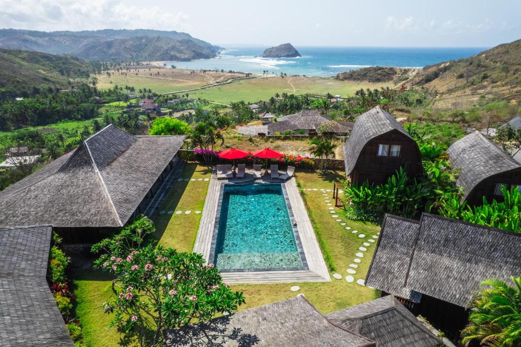 an aerial view of a resort with a swimming pool and the ocean at Villa Ellya in Kuta Lombok