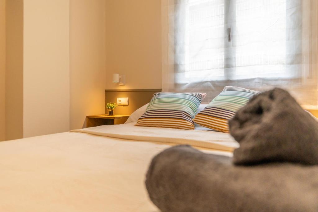 a bedroom with a bed with two pillows and a window at Port Cambrils in Cambrils