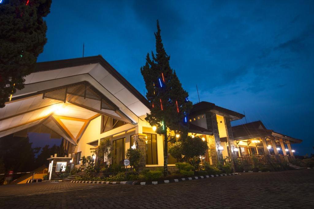 un edificio con luces delante de él por la noche en Sangga Buana Resort & Convention Hotel en Pacet