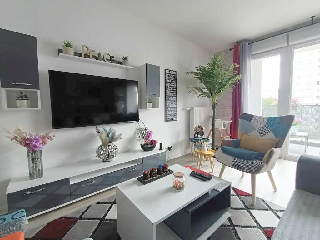 ein Wohnzimmer mit einem Flachbild-TV an der Wand in der Unterkunft Appartement 4 pièces - La Rose des Yvelines - Classé 3 étoiles in Trappes