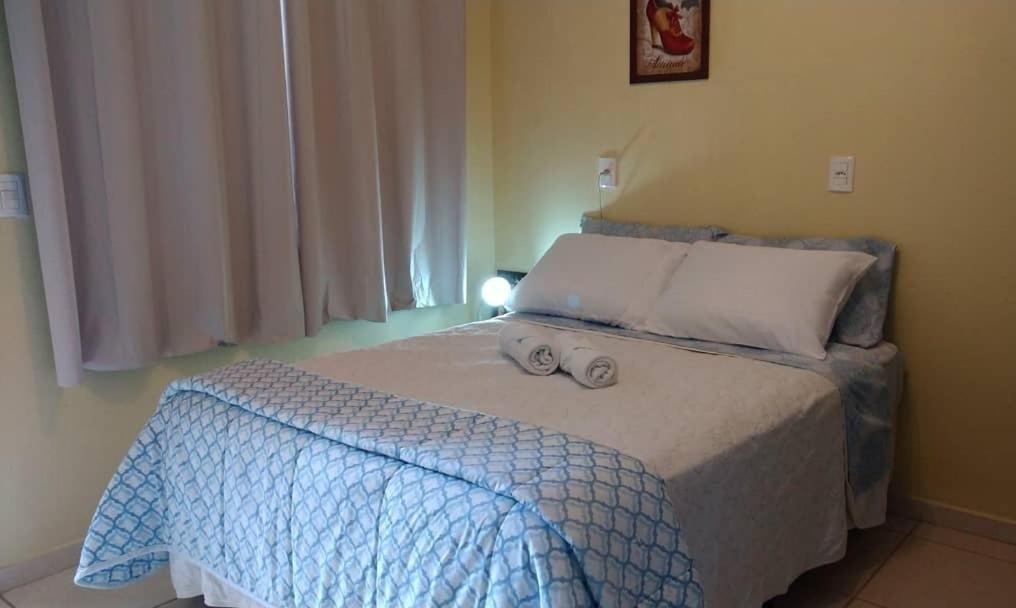 a bedroom with a bed with a blue comforter at Suíte alvenaria casal. in Guabiruba