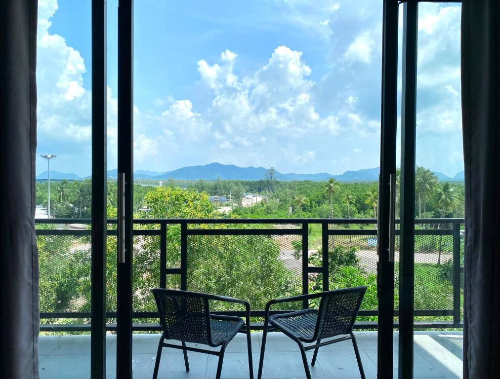 2 Stühle auf einem Balkon mit Bergblick in der Unterkunft De Saran Lanta in Ko Lanta