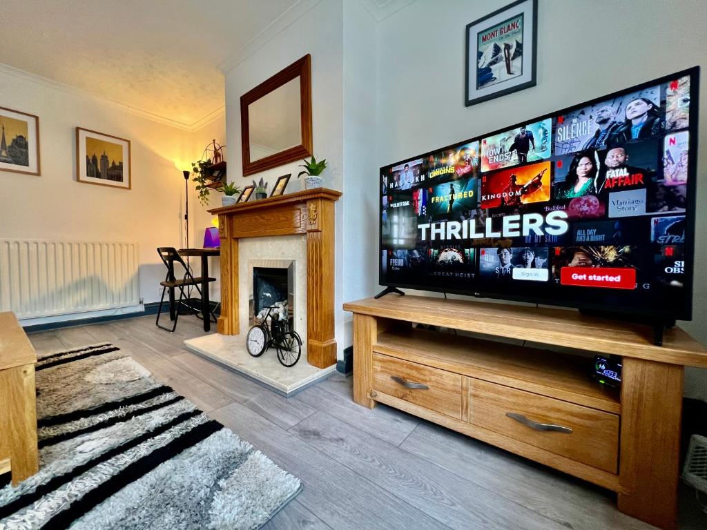 a living room with a large flat screen tv at Havenwood House - Serene Escape Cottage in Nottingham