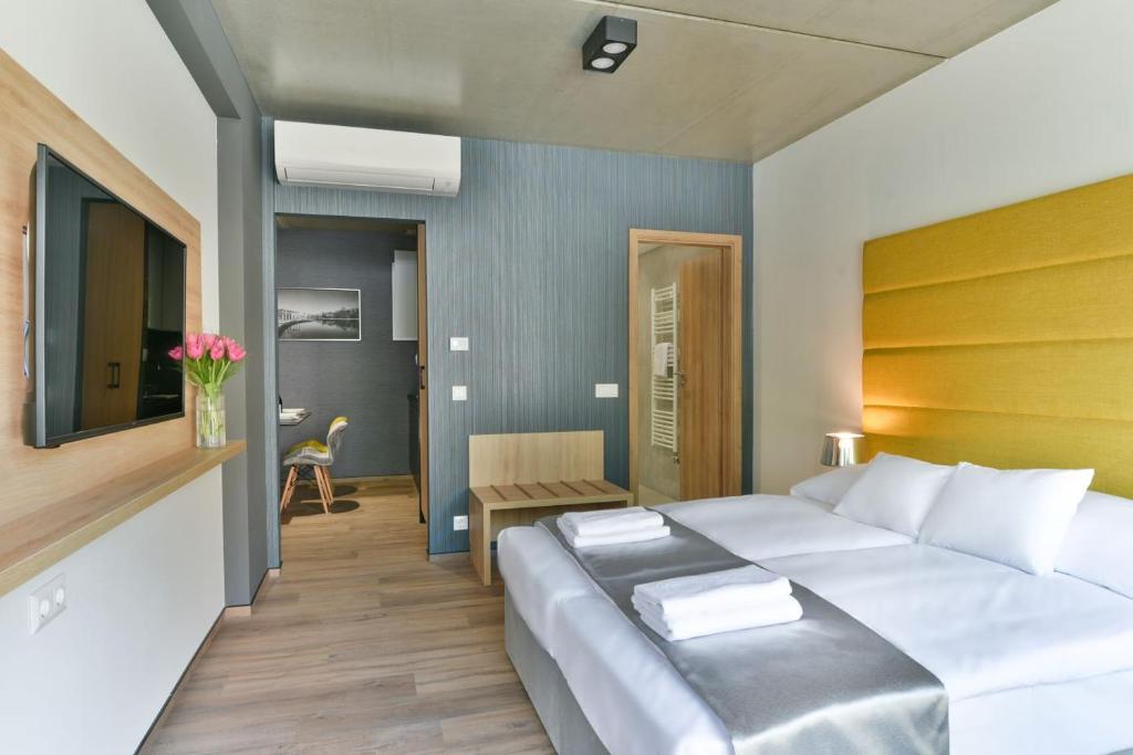 Un dormitorio con una gran cama blanca y una mesa en R31 Residence, en Sárvár