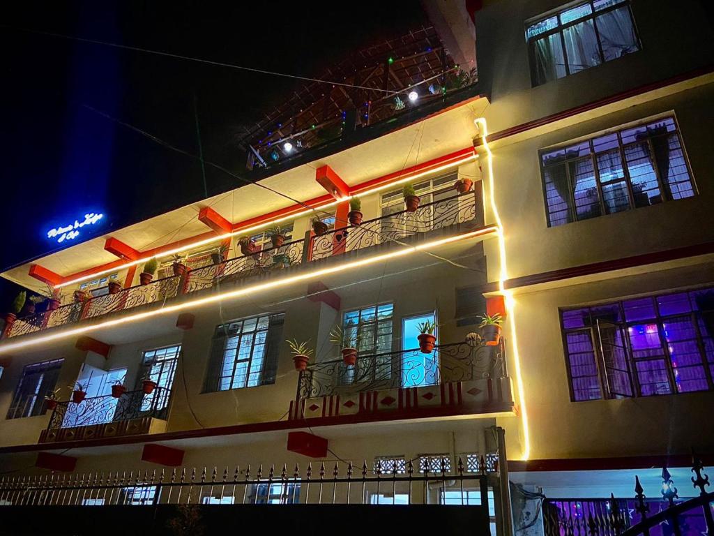 ein Gebäude mit Menschen auf den Balkonen in der Nacht in der Unterkunft Winnie's Lodge in Shillong