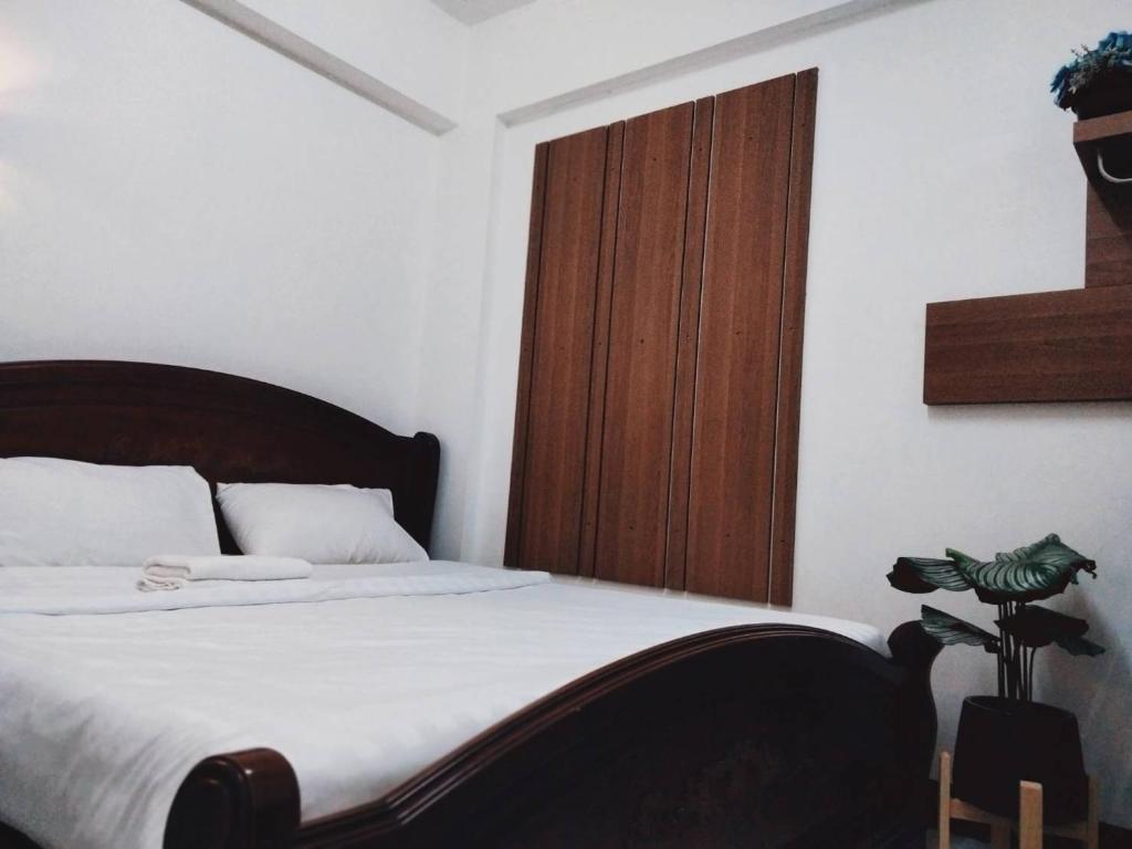 1 dormitorio con 1 cama grande y puerta de madera en Baan Rao Boutique Residence en Chiang Mai