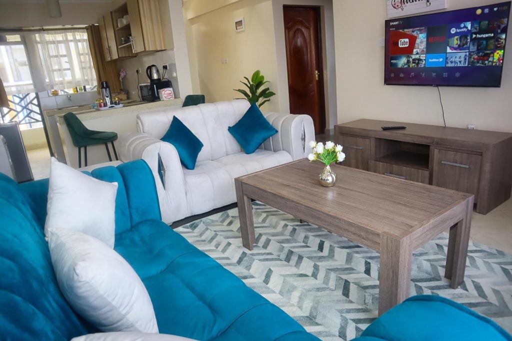 een woonkamer met een bank en een tafel bij Cosy Flamingo furnished apartments in Nakuru