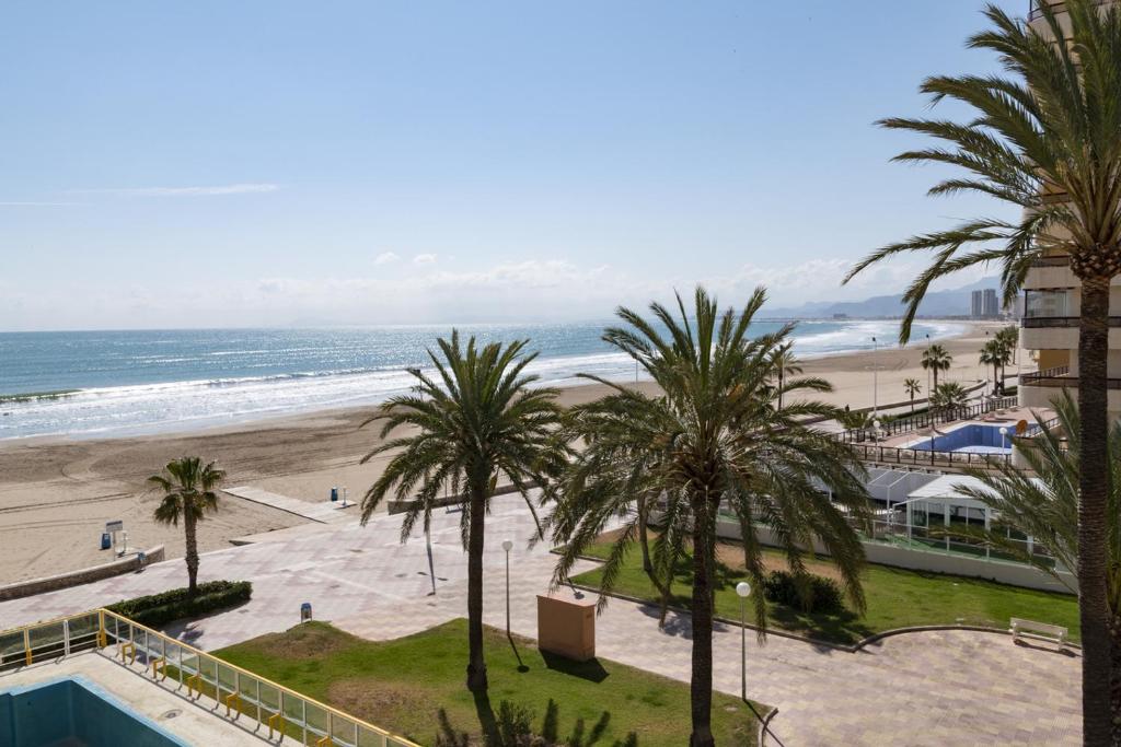 a view of a beach with palm trees and the ocean at Florazar 3, 3-C in Cullera