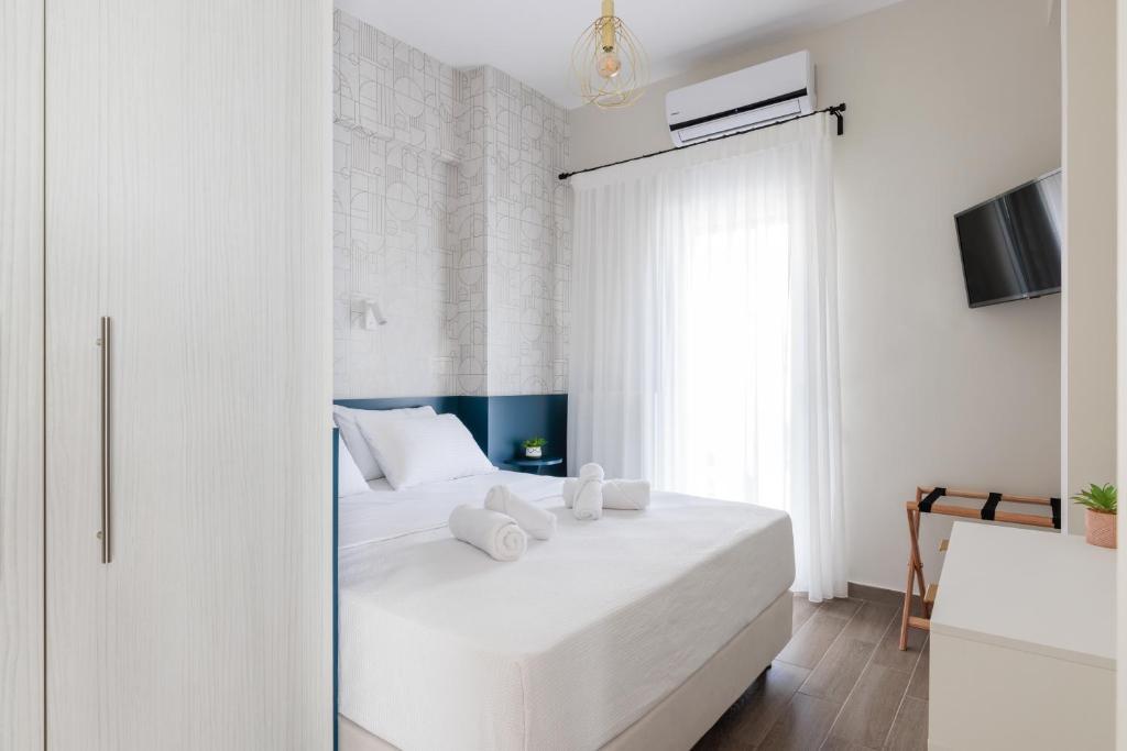a white bedroom with a white bed and a window at Penthouse No7 - #TIF Helexpo in Thessaloniki