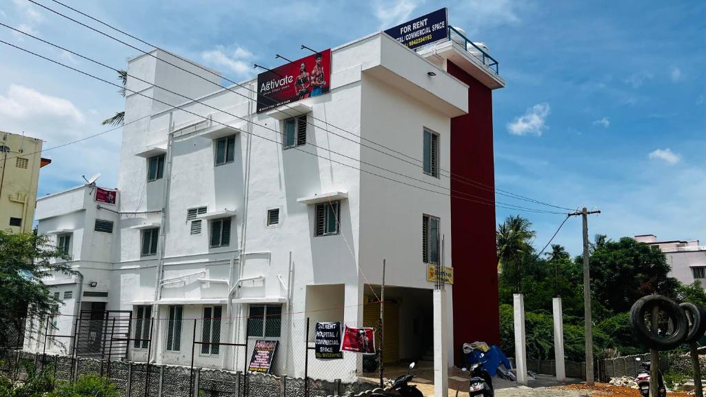 Ein weißes Gebäude mit einem roten Schild drauf. in der Unterkunft Hotel Star Nivas, Srirangam in Tiruchchirāppalli