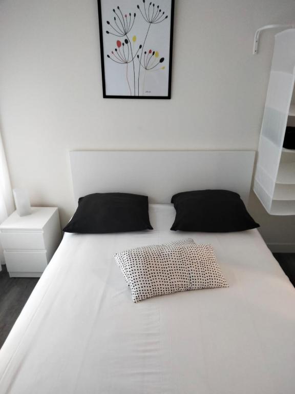 a white bed in a bedroom with a picture on the wall at Le Cosy Agen-Proche Gare-Salle de sport-Vidéoprojection in Agen