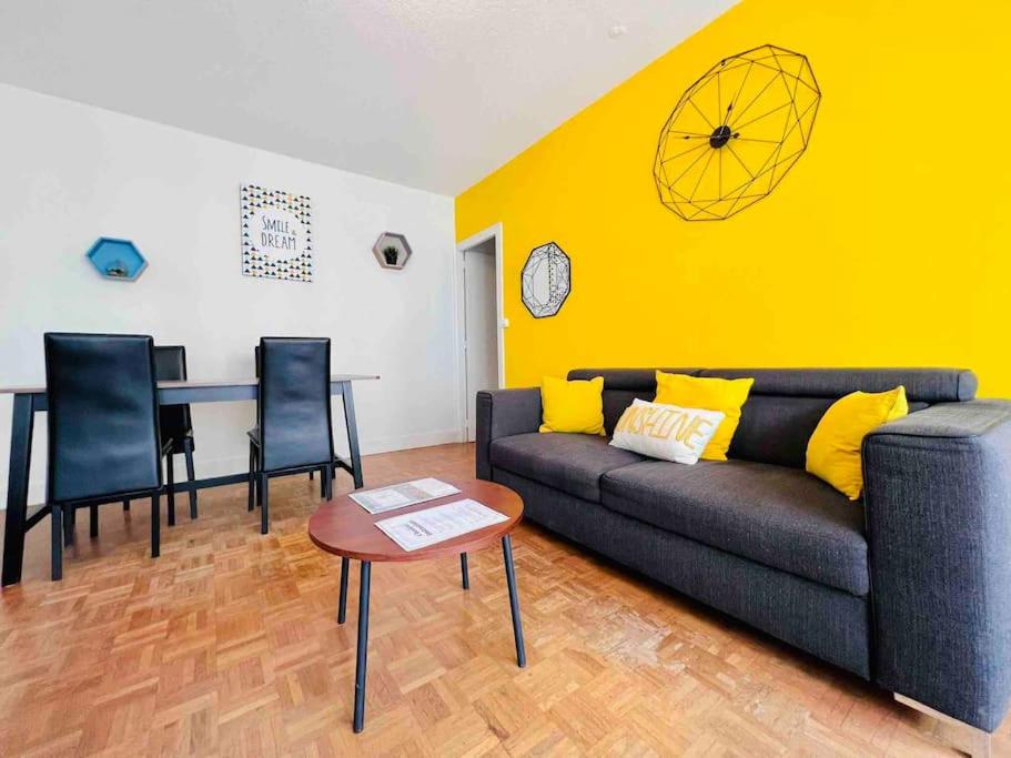 sala de estar con sofá y mesa en Les Facs : Apt 6 Prs, 3 ch, Balcon et Parking, en Dijon