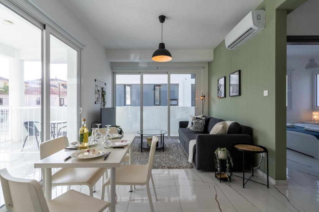uma sala de estar com uma mesa e um sofá em Artemis 1-Bedroom Apartment in Larnaca em Larnaka