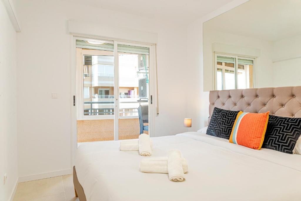 アレナレス・デル・ソルにあるMyflats Premium Arenales Hillsの白いベッドルーム(大型ベッド、タオル付)