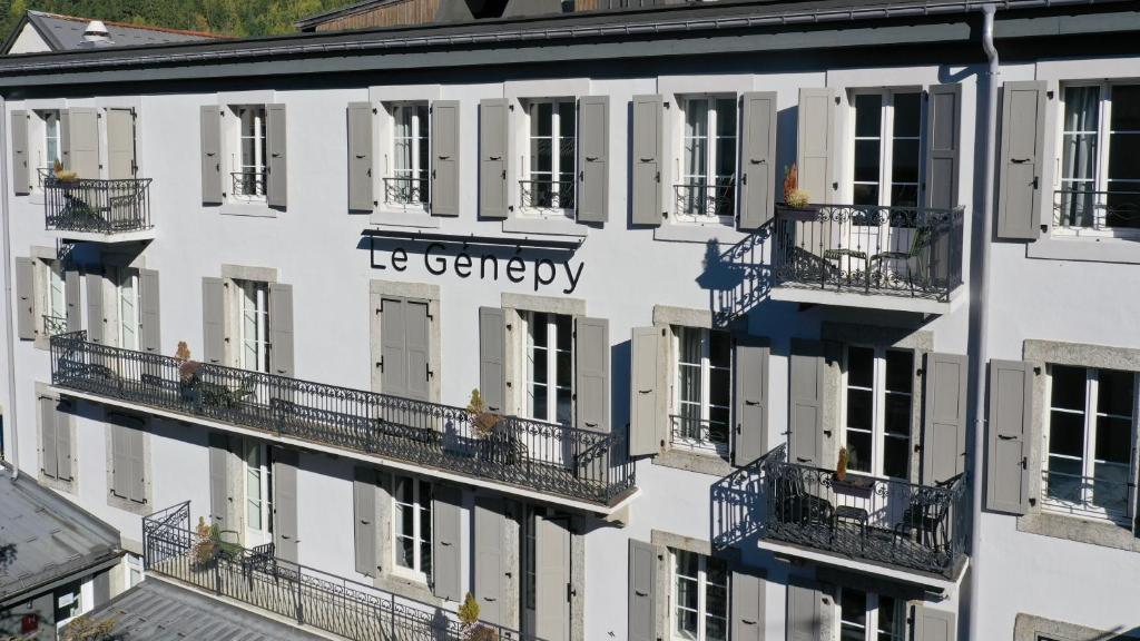 Le Génépy - Appart'hôtel de Charme في شامونيه مون بلان: اطلالة جوية على مبنى ابيض فيه بلكونات