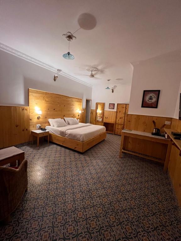 a large bedroom with a large bed and a table at hotel saina inn in Dehradun