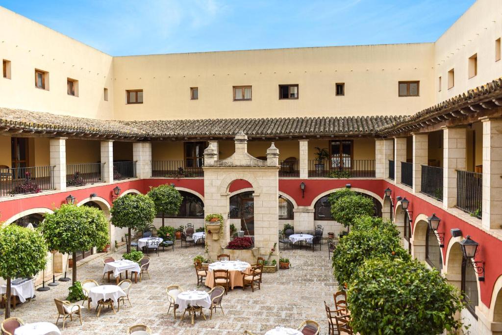 einen Innenhof mit Tischen und Stühlen in einem Gebäude in der Unterkunft ALEGRIA Bodega Real in El Puerto de Santa María