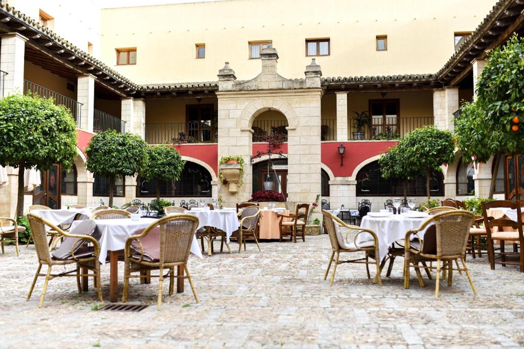 an outdoor patio with tables and chairs in a courtyard at ALEGRIA Bodega Real in El Puerto de Santa María