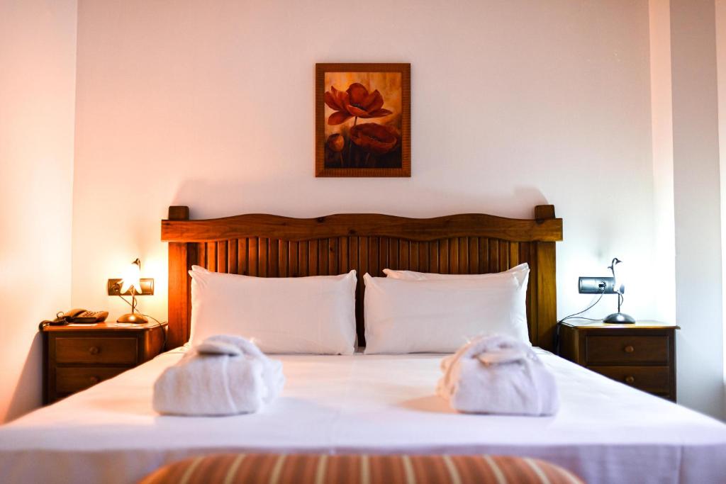 a bedroom with a bed with towels on it at ALEGRIA Bodega Real in El Puerto de Santa María