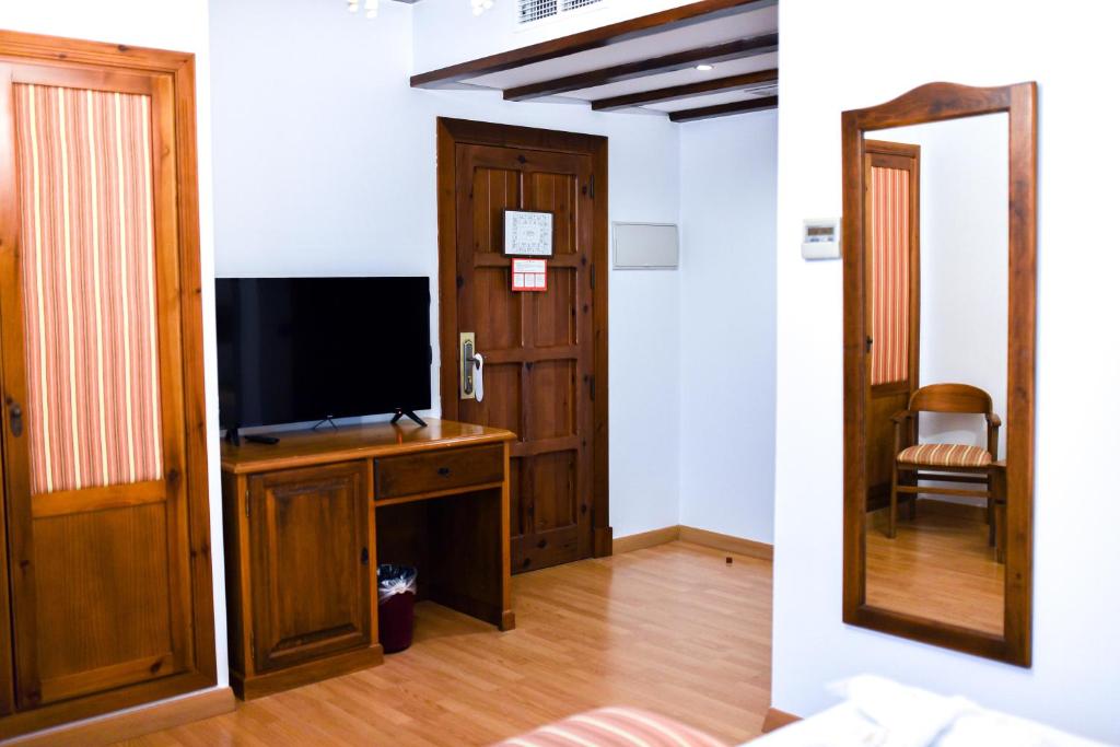 a living room with a television and a mirror at ALEGRIA Bodega Real in El Puerto de Santa María