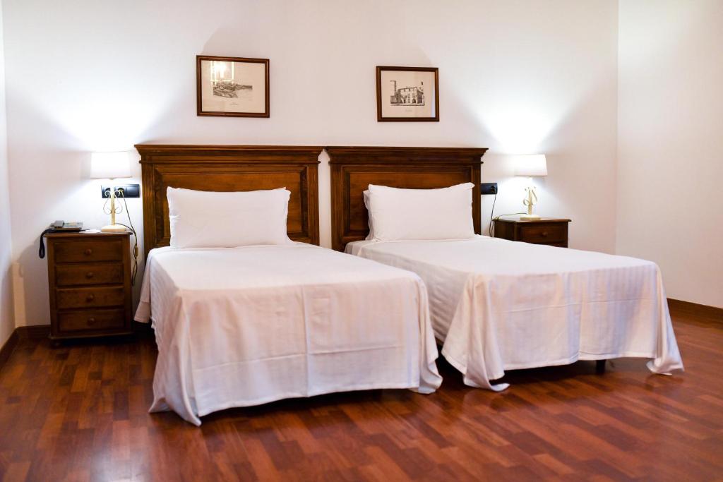 a bedroom with two beds with white sheets at ALEGRIA Bodega Real in El Puerto de Santa María