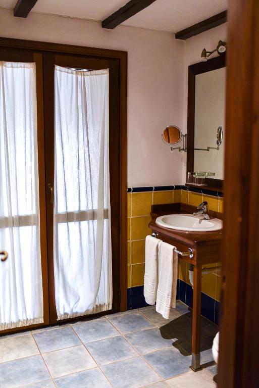 a bathroom with a sink and a mirror at ALEGRIA Bodega Real in El Puerto de Santa María