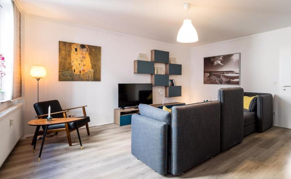uma sala de estar com um sofá e uma mesa em Homefy Altstadt Apartment für 6 Personen, mit 2 Bädern und Balkon em Dusseldorf