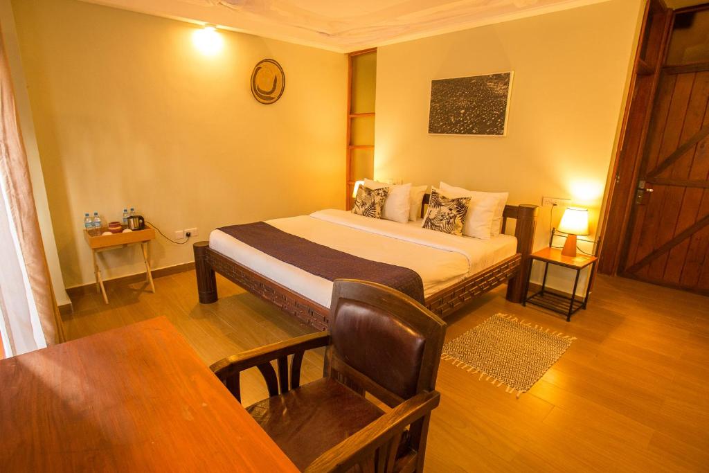 een slaapkamer met een bed en een tafel in een kamer bij Amani Safari Lodge and Restaurant in Arusha