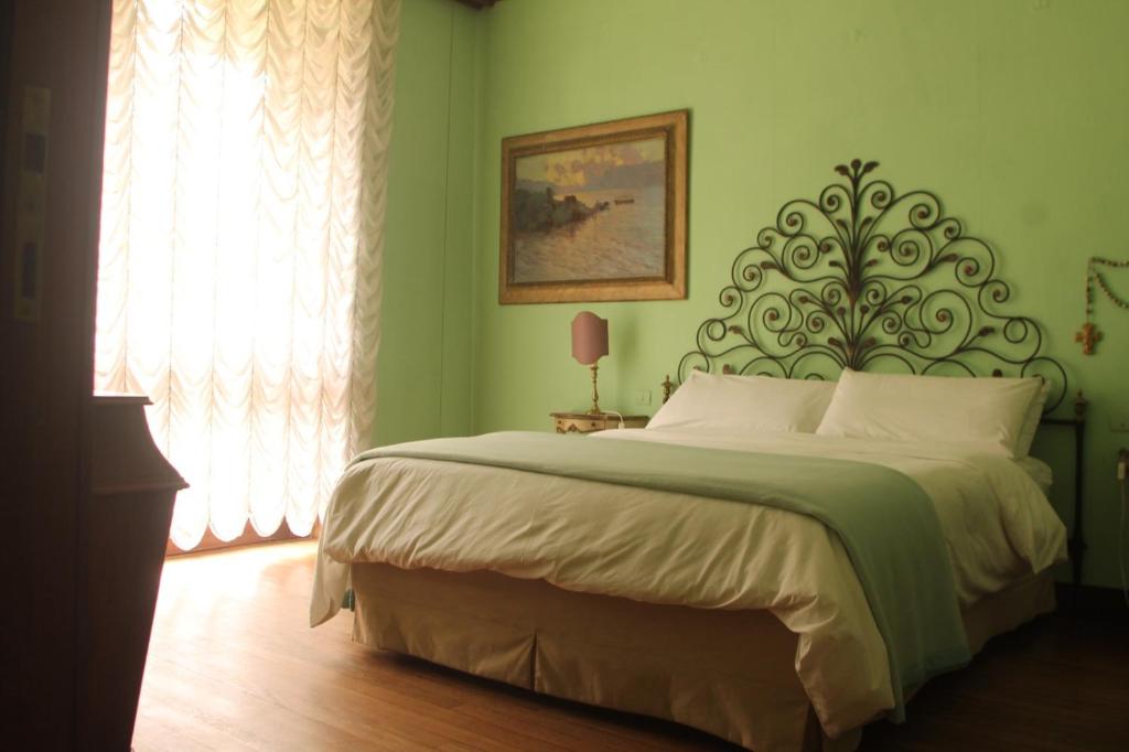 1 dormitorio con 1 cama grande en una habitación verde en Villa Inella, en Oggiono