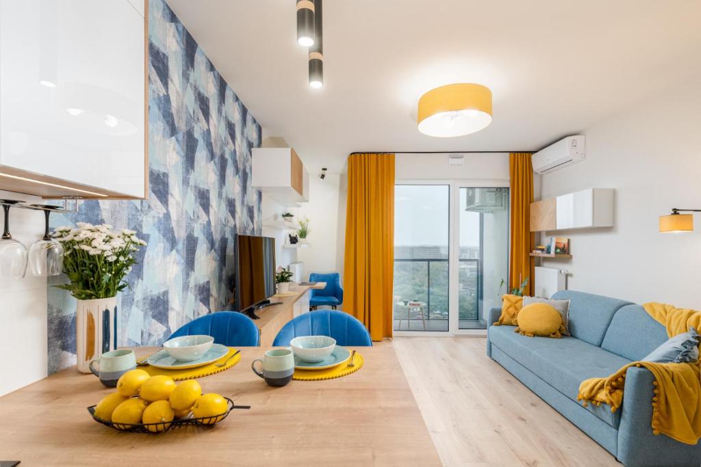 a living room with a blue couch and a table at BlueApart Mogilska in Kraków