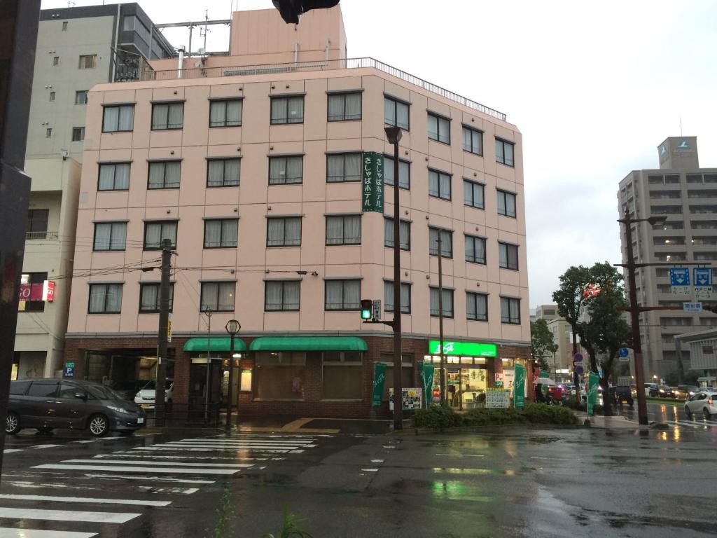 een gebouw in een stadsstraat met een verkeerslicht bij Kisyaba Hotel in Kagoshima