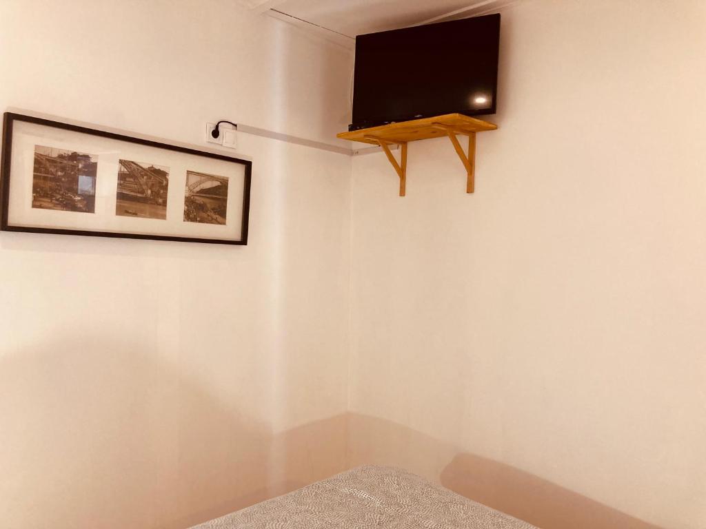 een kamer met een flatscreen-tv aan de muur bij Casa Camões II in Porto