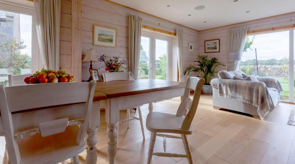 uma cozinha e sala de jantar com mesa e cadeiras em Netherton Farm Lodge em Kemnay