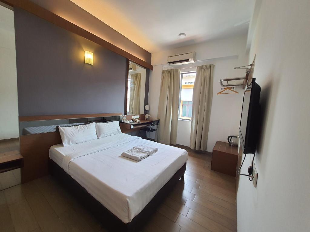 una camera d'albergo con letto e TV di Hotel Golden View Nilai a Nilai