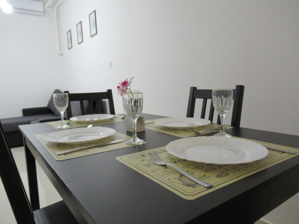 a dining room table with plates and glasses on it at Relax Beach Apartment in Split
